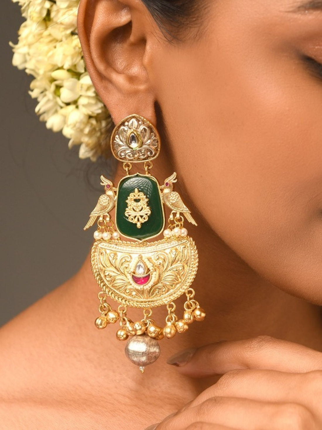 Gold Plated Traditional Earrings with intricate detailing and green enamel worn on ear by model