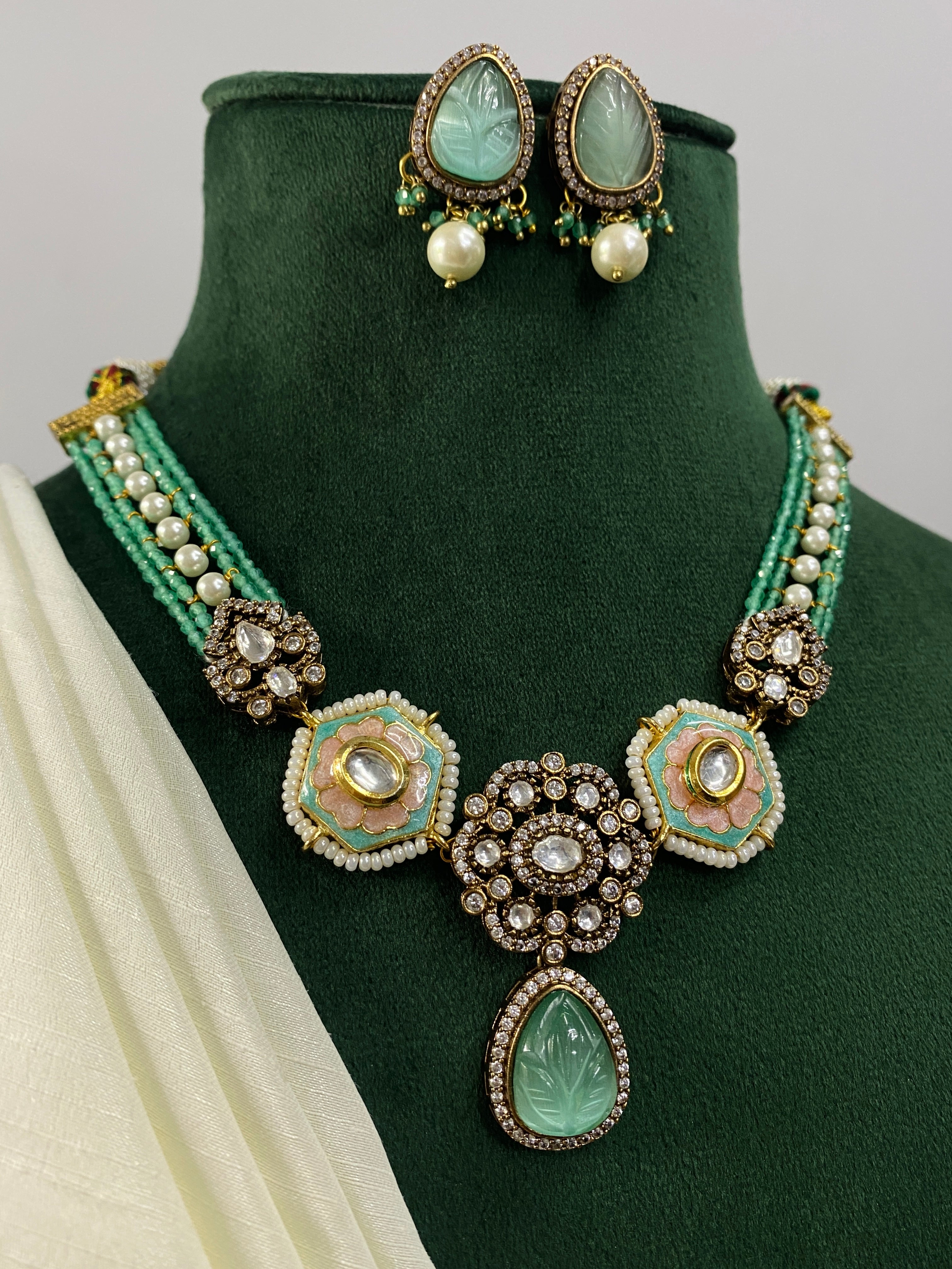 High Quality Gold Plated Victorian Necklace with green stones and pearl earrings displayed on green velvet stand