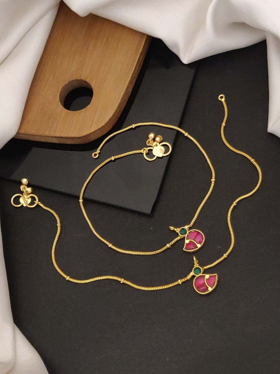 Minimal Gold Plated Pink Kempstone Bird Anklets by Abdesignsjewellery displayed on black and white fabric