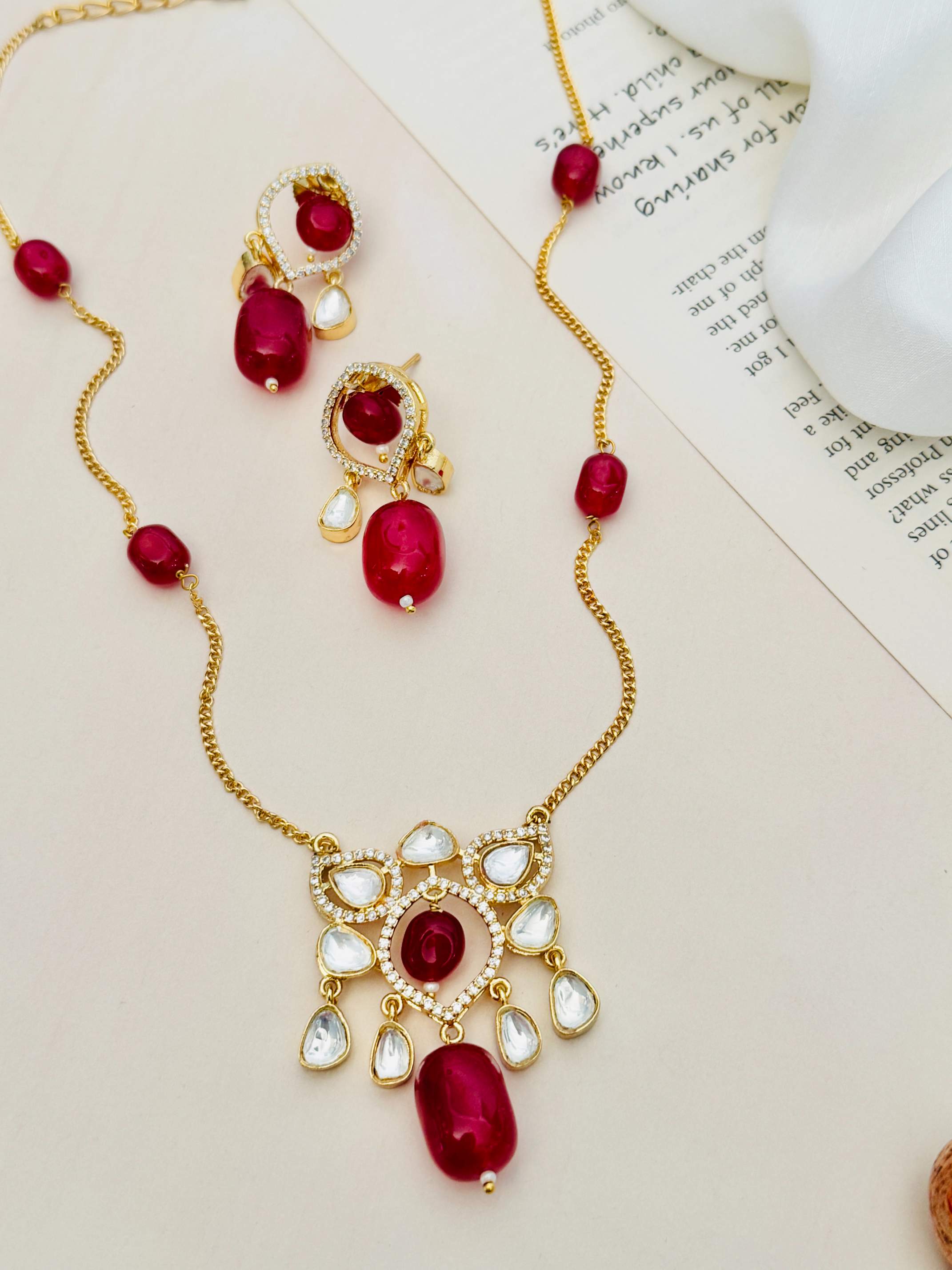 Abdesignsjewellery Premium Gold Plated Polki Pendant Set with red stones and white crystal accents on a gold chain