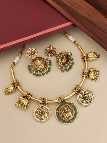 Antique gold temple hasli necklace set with emerald green stones, styled for a Kanjivaram silk saree