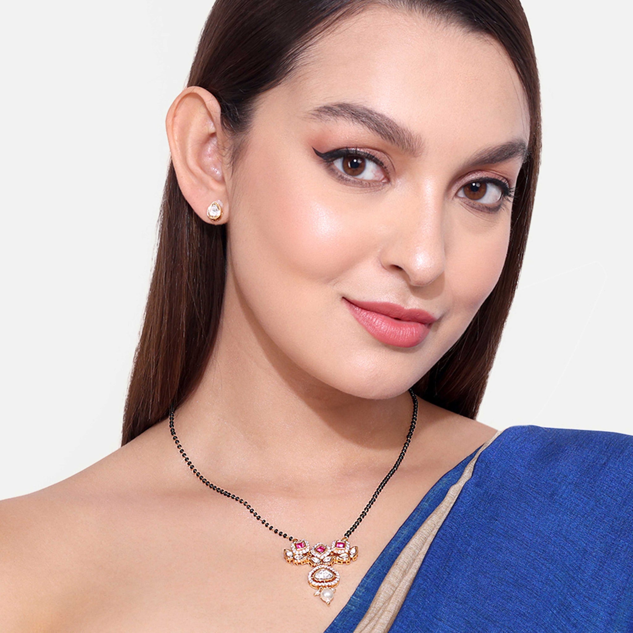 Woman wearing elegant Kundan Mangalsutra necklace with intricate gemstone design and matching earrings