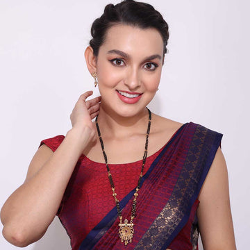 Woman wearing a traditional Temple Mangalsutra necklace with intricate gold pendant and black beads