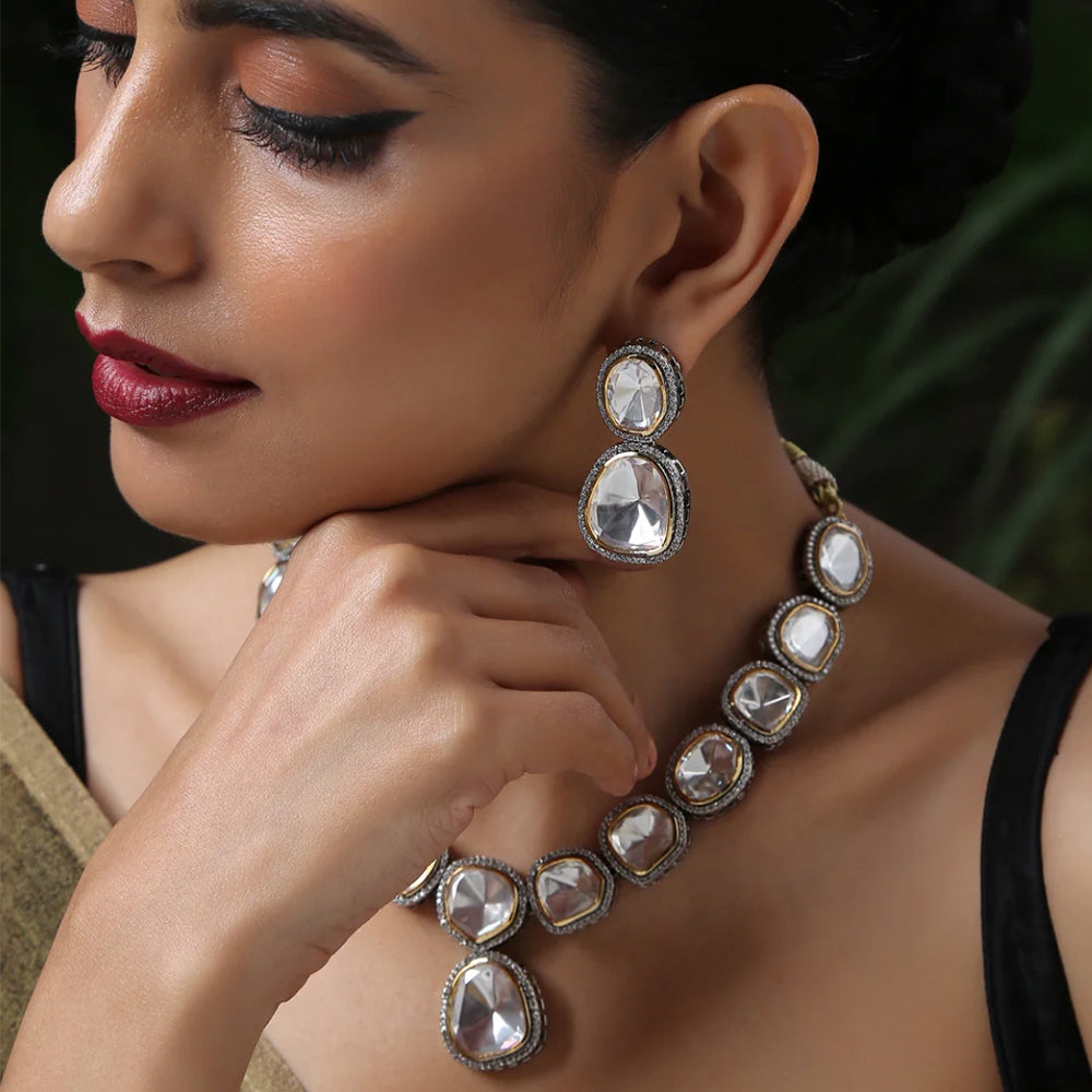 Elegant bridal necklace set with large clear stones worn by woman with matching earrings