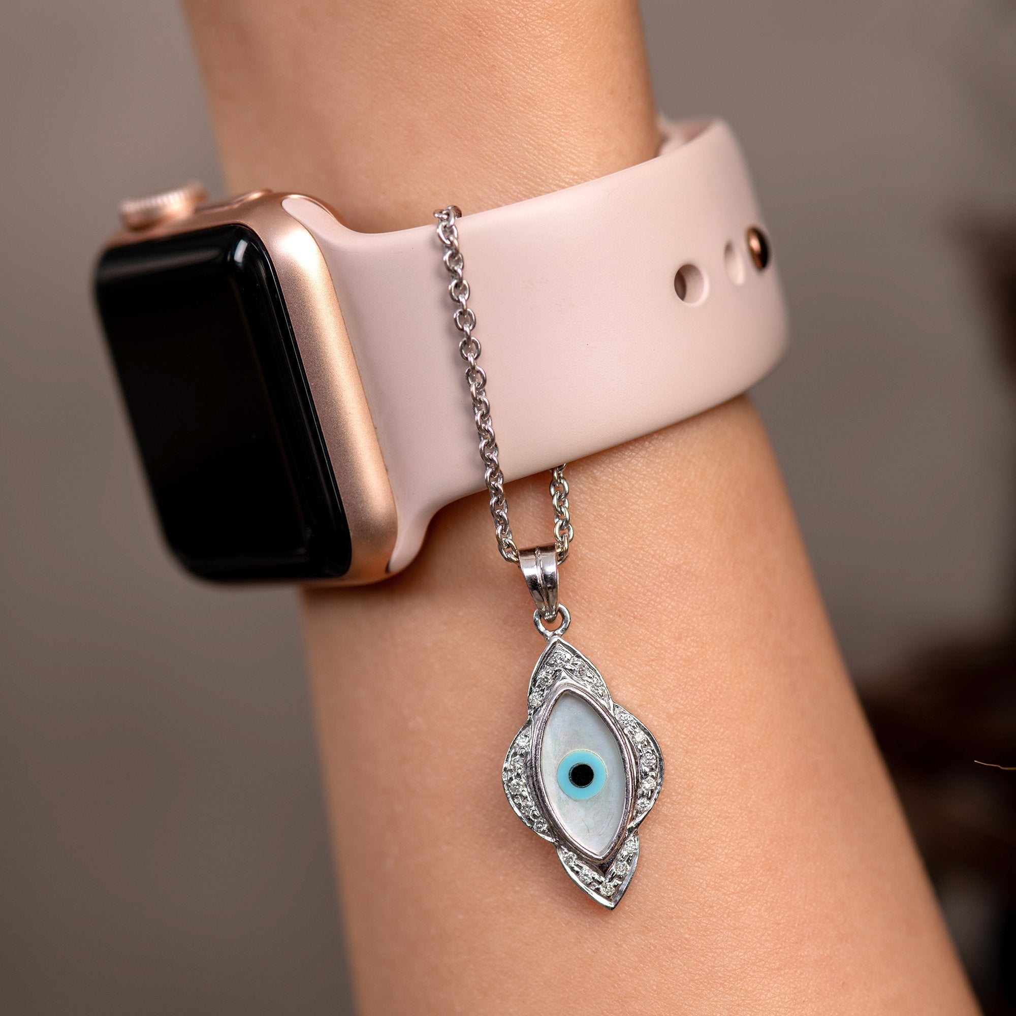 Stylish watch charm for women with a silver chain and eye design hanging from a smartwatch strap
