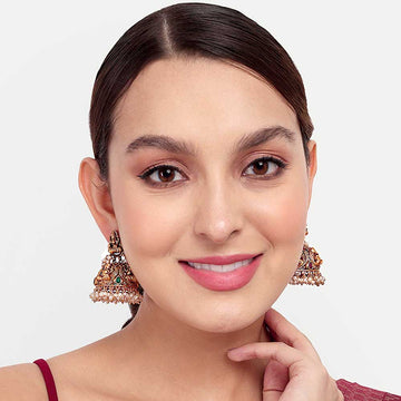 Close-up of woman wearing intricate festive earring with traditional design and colorful details