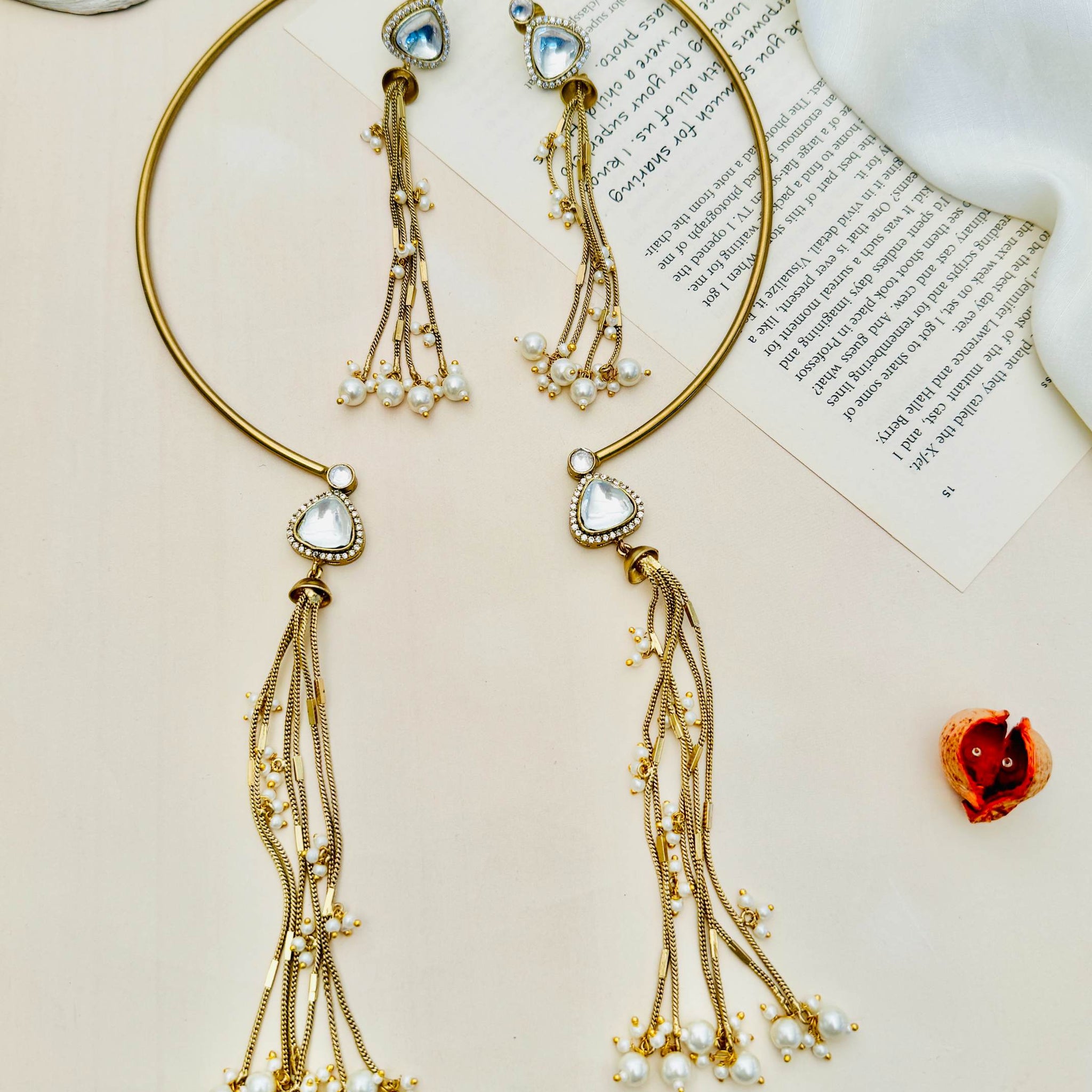 Elegant Hasli Necklace with matching earrings featuring gold finish and pearl tassel details on a neutral background