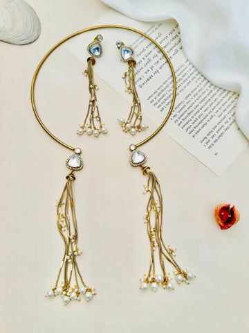 Elegant Hasli Necklace with matching earrings featuring gold finish and pearl tassel details on a neutral background
