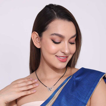 Woman wearing a German Silver Mangalsutra necklace with a decorative pendant and blue saree