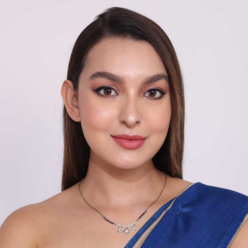 Elegant Silver Mangalsutra necklace worn by woman in blue saree with minimal makeup and straight hair