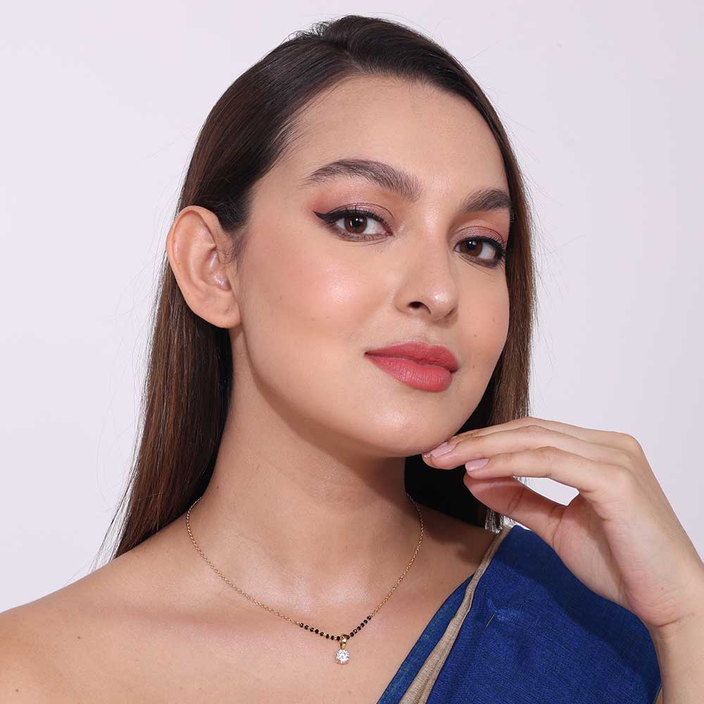 Elegant Morden Mangalsutra necklace with black beads and pendant worn by woman in blue saree