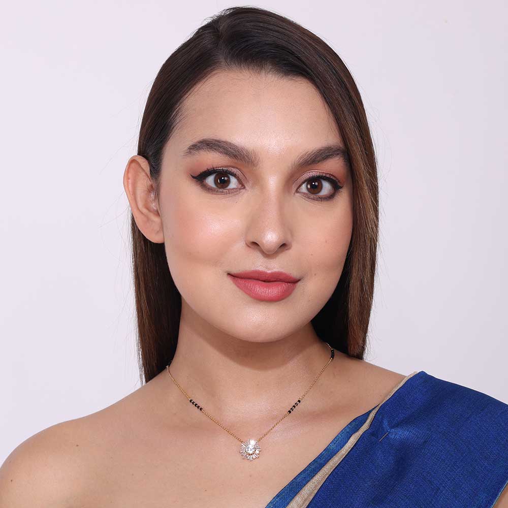 Portrait of woman wearing a delicate festive mangalsutra with a floral pendant and black beads necklace