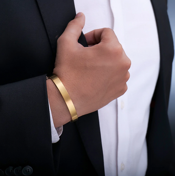 Close-up of a man wearing Men's Jewellery gold bracelet with formal black suit and white shirt