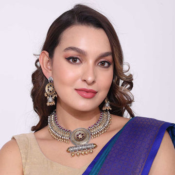 Woman wearing traditional jewelry featuring dual tone necklaces with intricate design and pairing with ethnic earrings