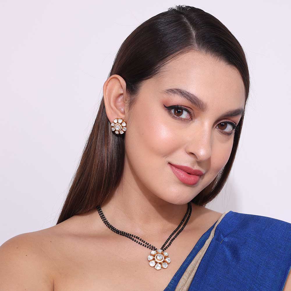 Elegant woman wearing a Pachi Kundan Mangalsutra with matching earrings and blue saree