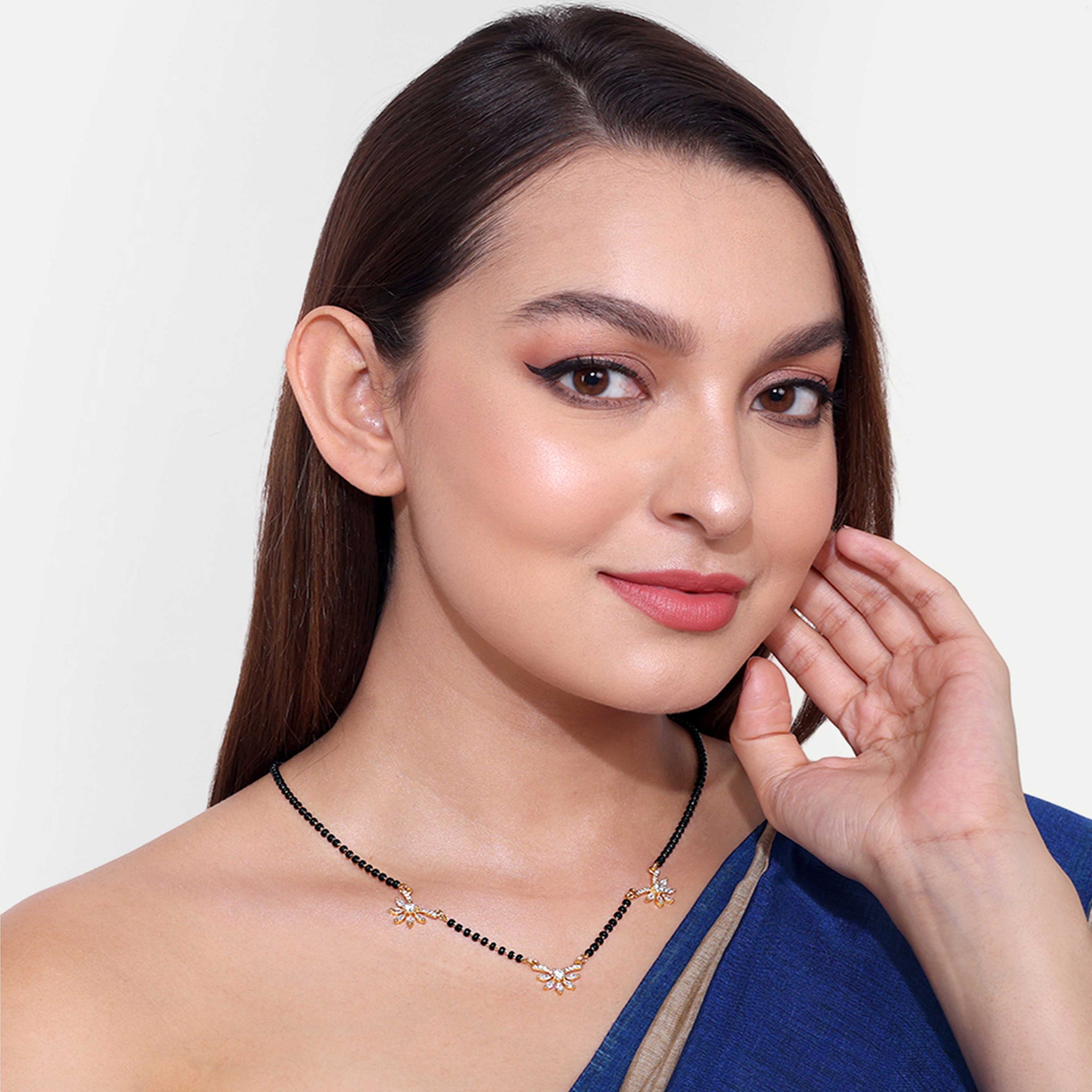 Woman wearing elegant American Diamond Mangalsutra with black beads and floral design on chain