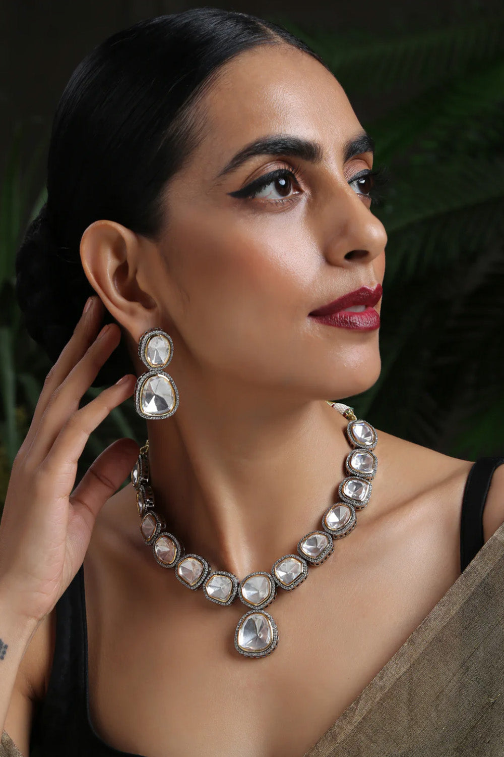 Elegant woman wearing a necklace and earrings from the High End Jewellery Collection