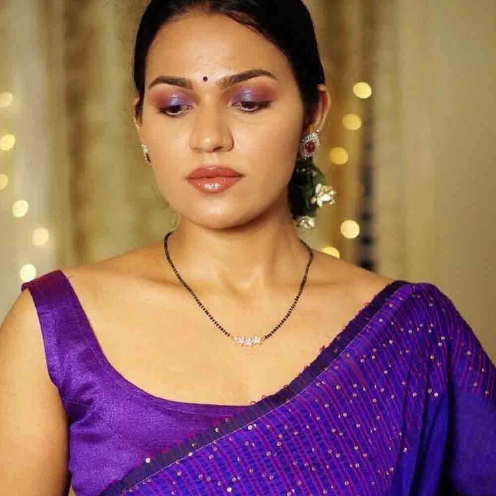 Woman wearing a delicate Rose Gold Mangalsutra with a purple saree in soft lighting