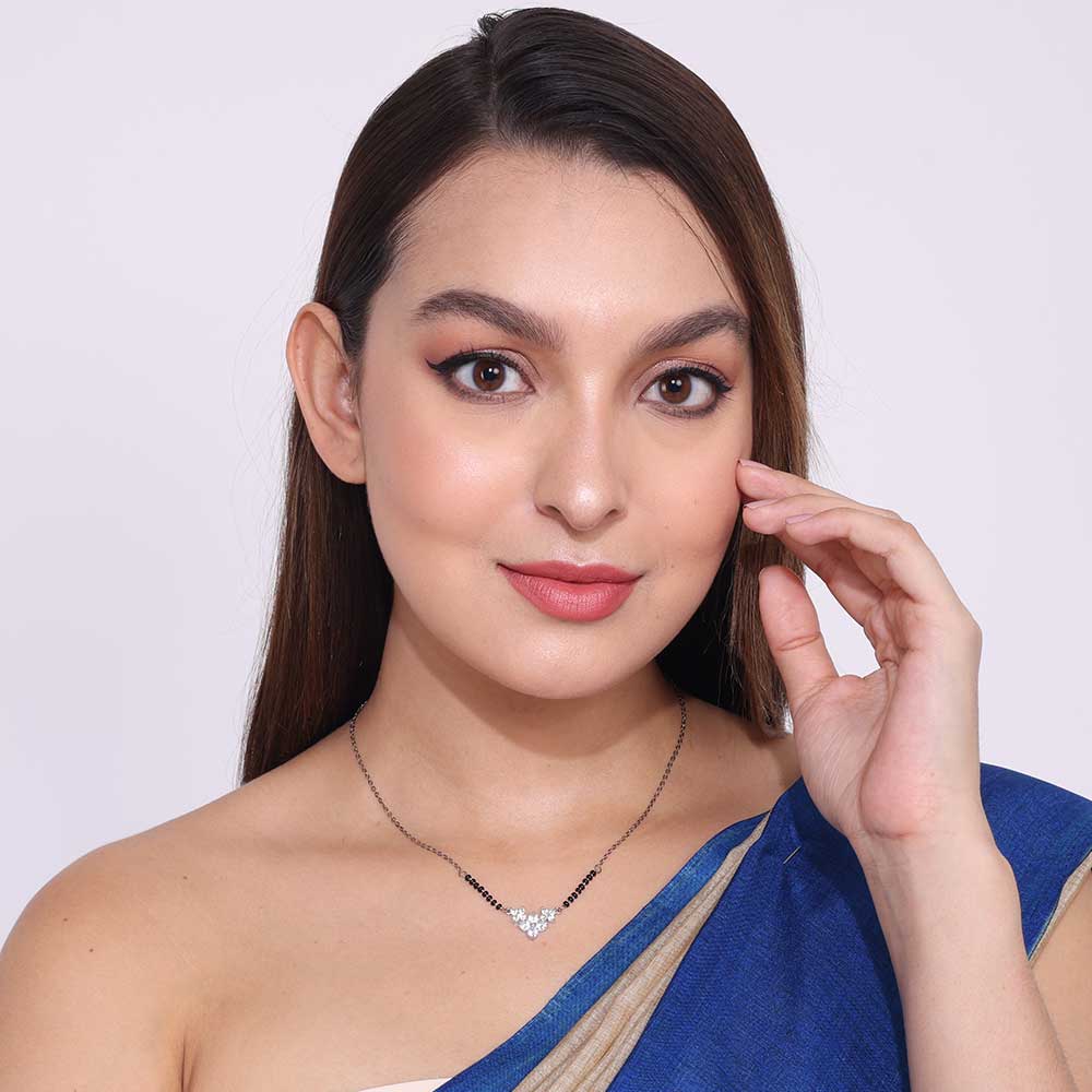 Woman wearing elegant Office Wear Mangalsutra with black beads and heart pendant paired with blue saree