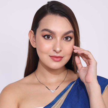 Woman wearing elegant Office Wear Mangalsutra with black beads and heart pendant paired with blue saree