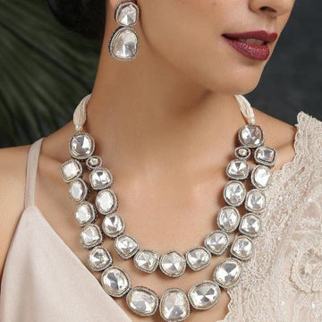 Elegant affordable layered necklaces with large clear stones worn with matching earrings on woman