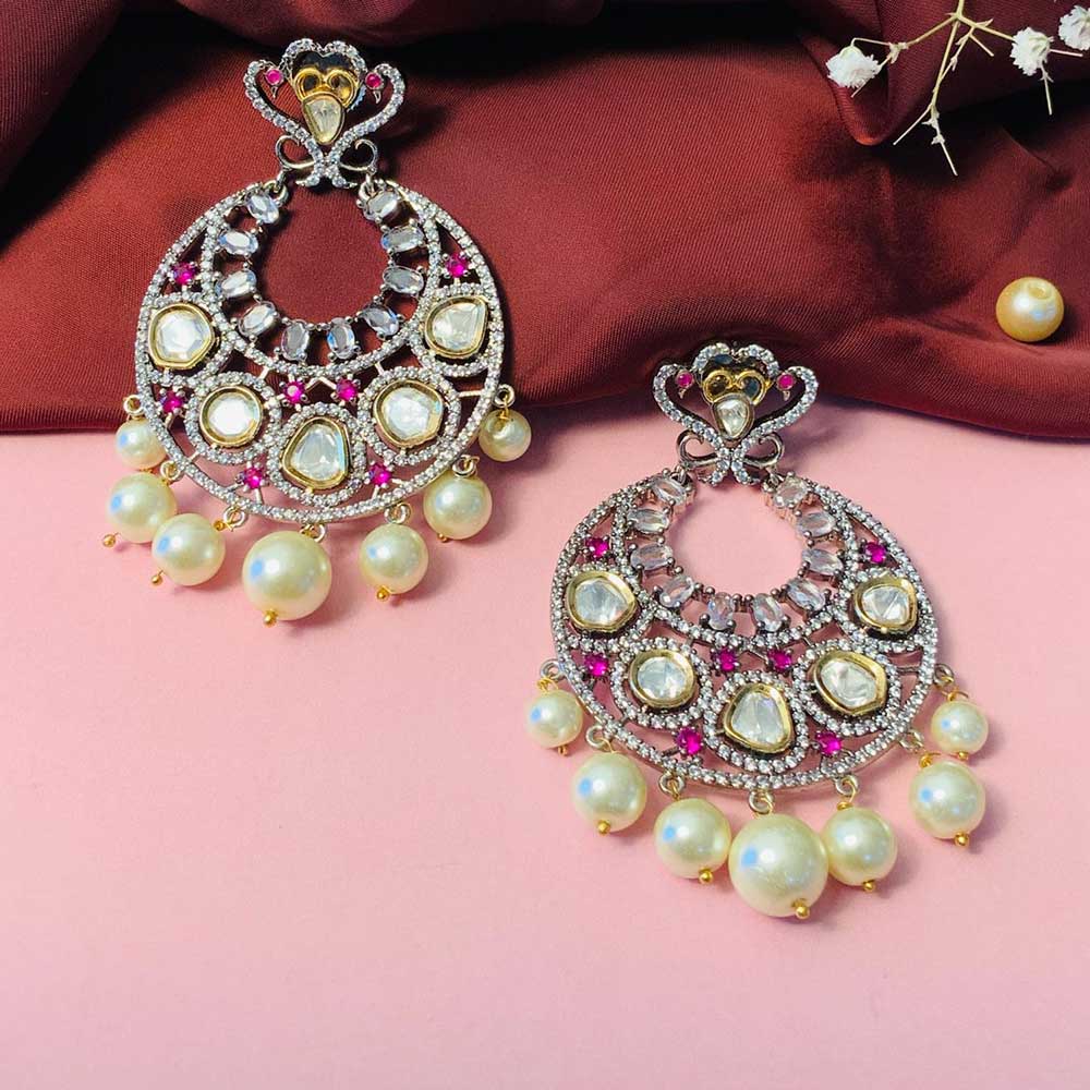 Elegant Chandbalis Earring with pearls and intricate gemstone detailing on a pink background