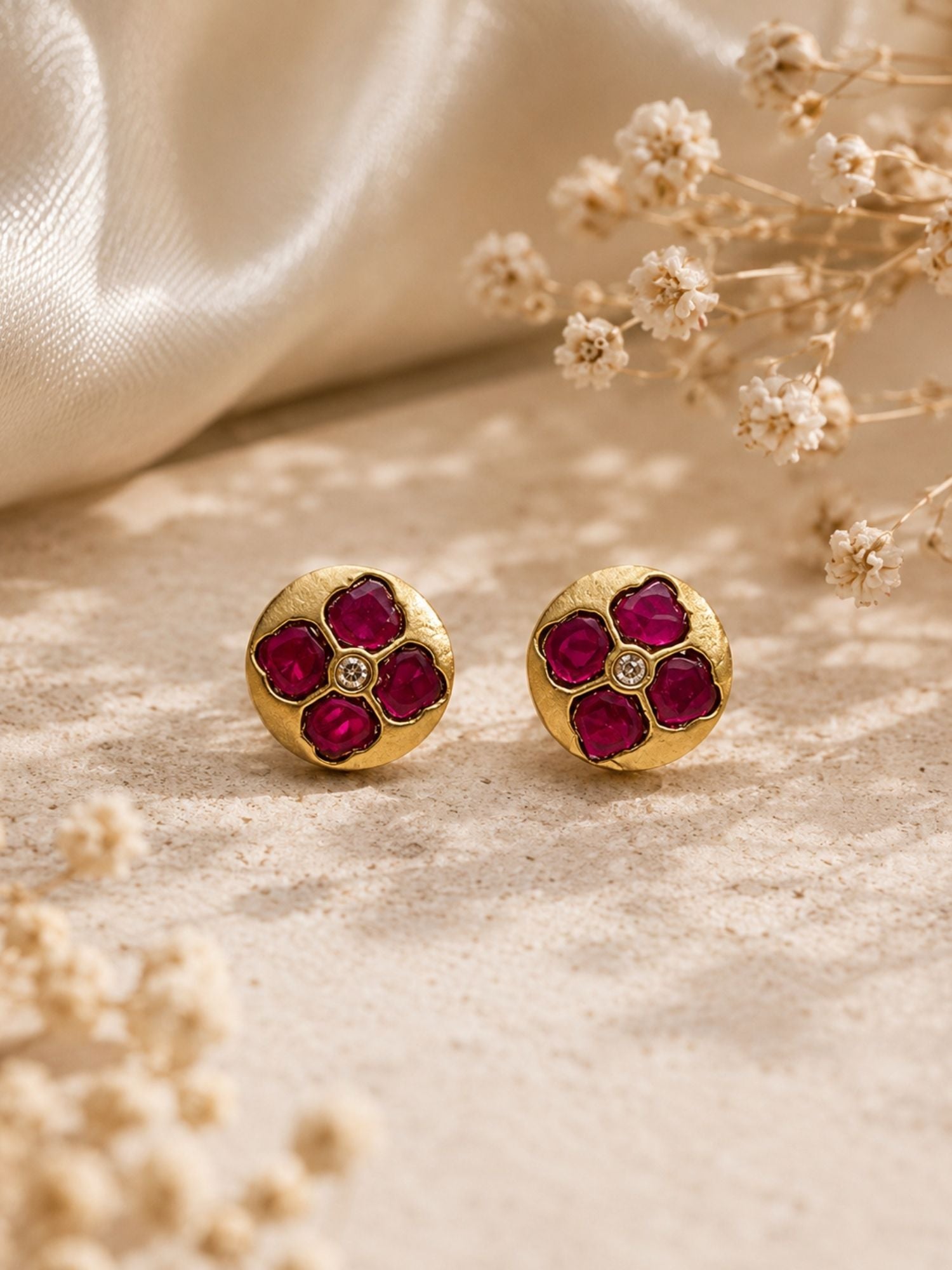 Matching pink Kundan floral stud earrings from the layered chain necklace set, close-up on beige stone