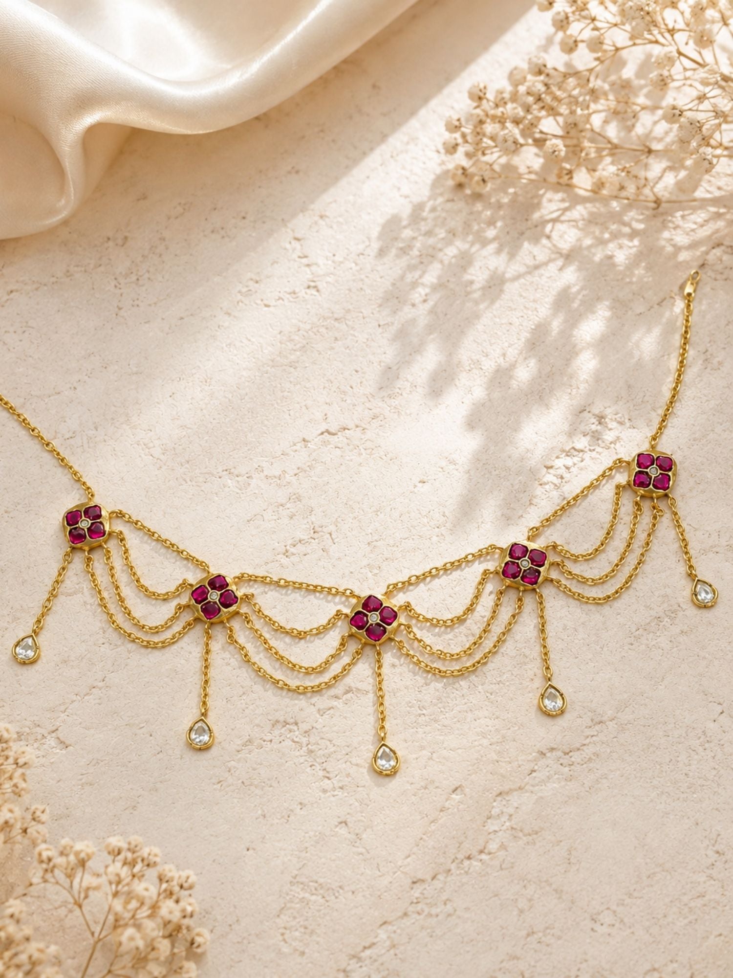 Gold plated pink Kundan floral layered chain necklace flat lay showing five floral motifs and teardrop drops