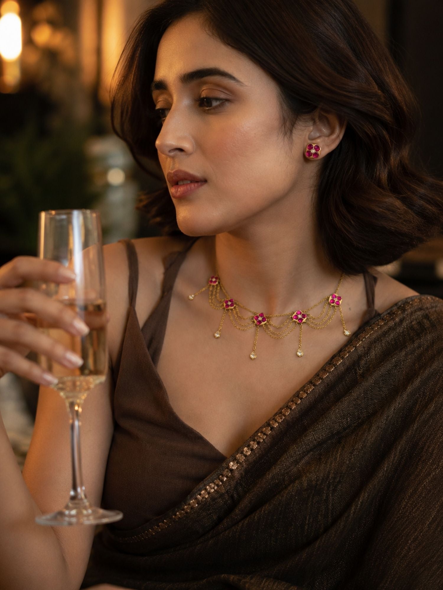 Model in brown saree wearing pink Kundan floral chain necklace set with studs, evening party styling
