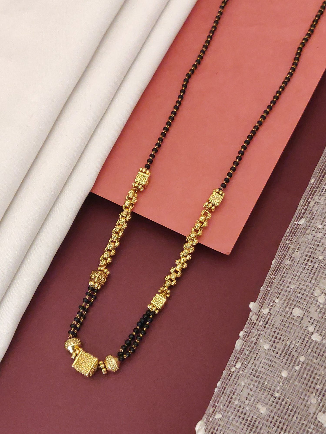 Abdesigns Gold-Plated Black Beads Mangalsutra featuring gold plated pendant and double strand black beads for bridal wear