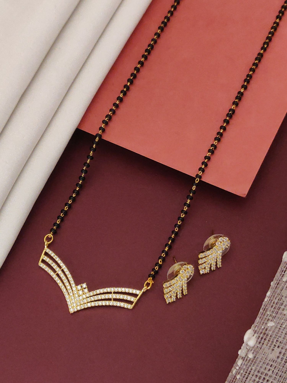 Abdesigns Gold-Plated CZ Mangalsutra with Earrings.. V-shaped CZ pendant and matching earrings on black bead chain