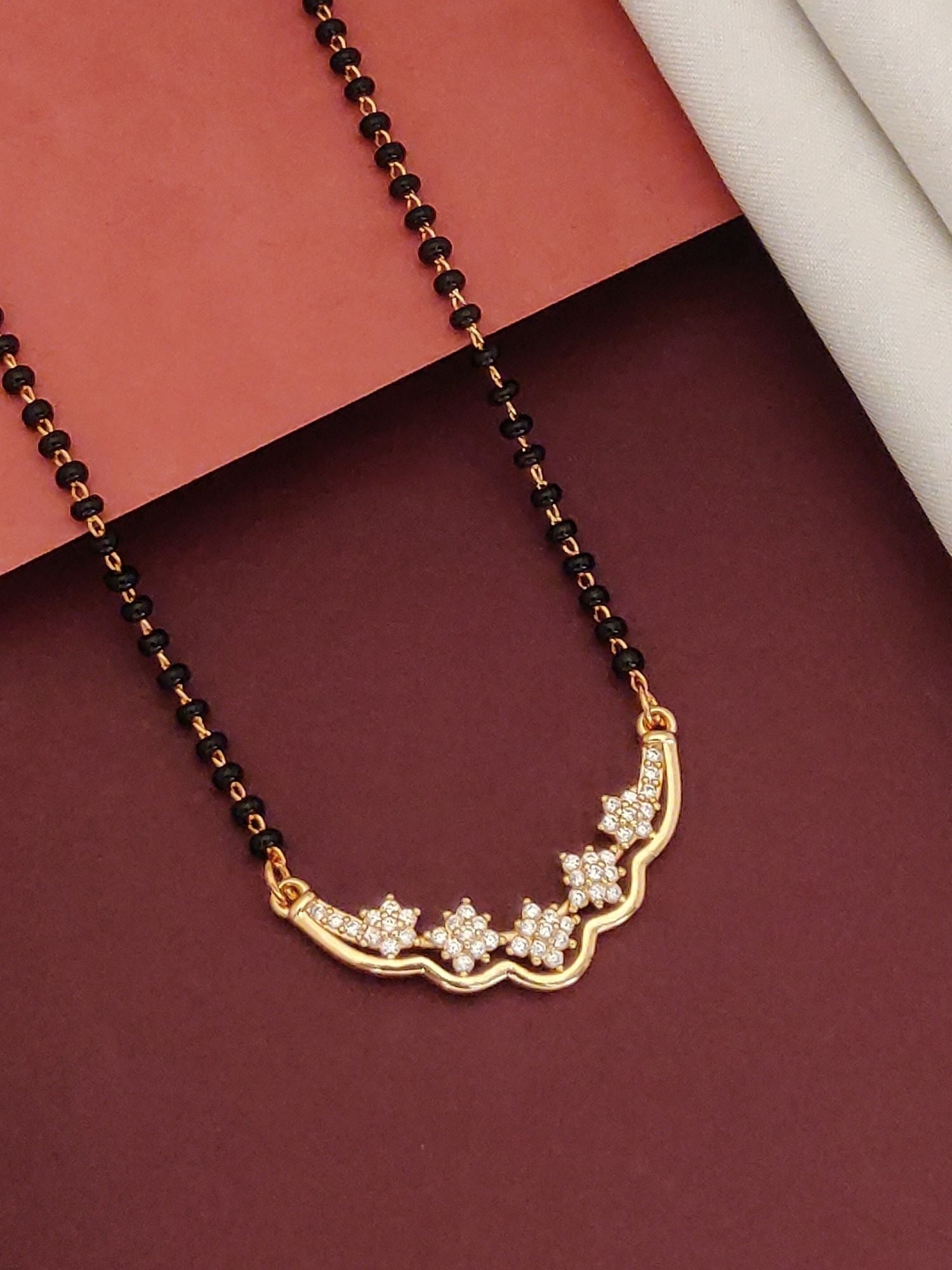 Abdesigns Gold-Plated Mangalsutra Black Beads delicate gold pendant with floral cubic zirconia accents on black bead chain