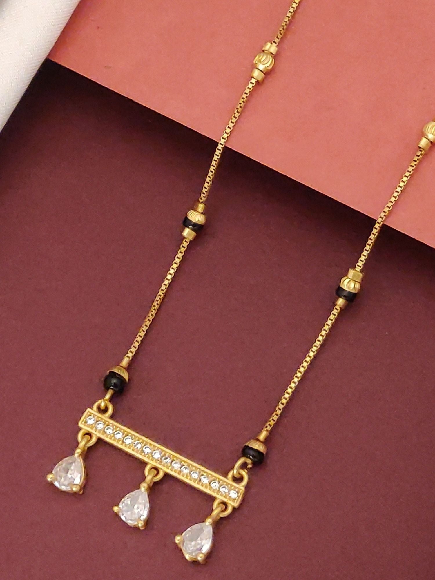 Abdesigns Gold-Plated Mangalsutra with CZ Drops . Gold plated mangalsutra with black beads and three teardrop CZ pendants