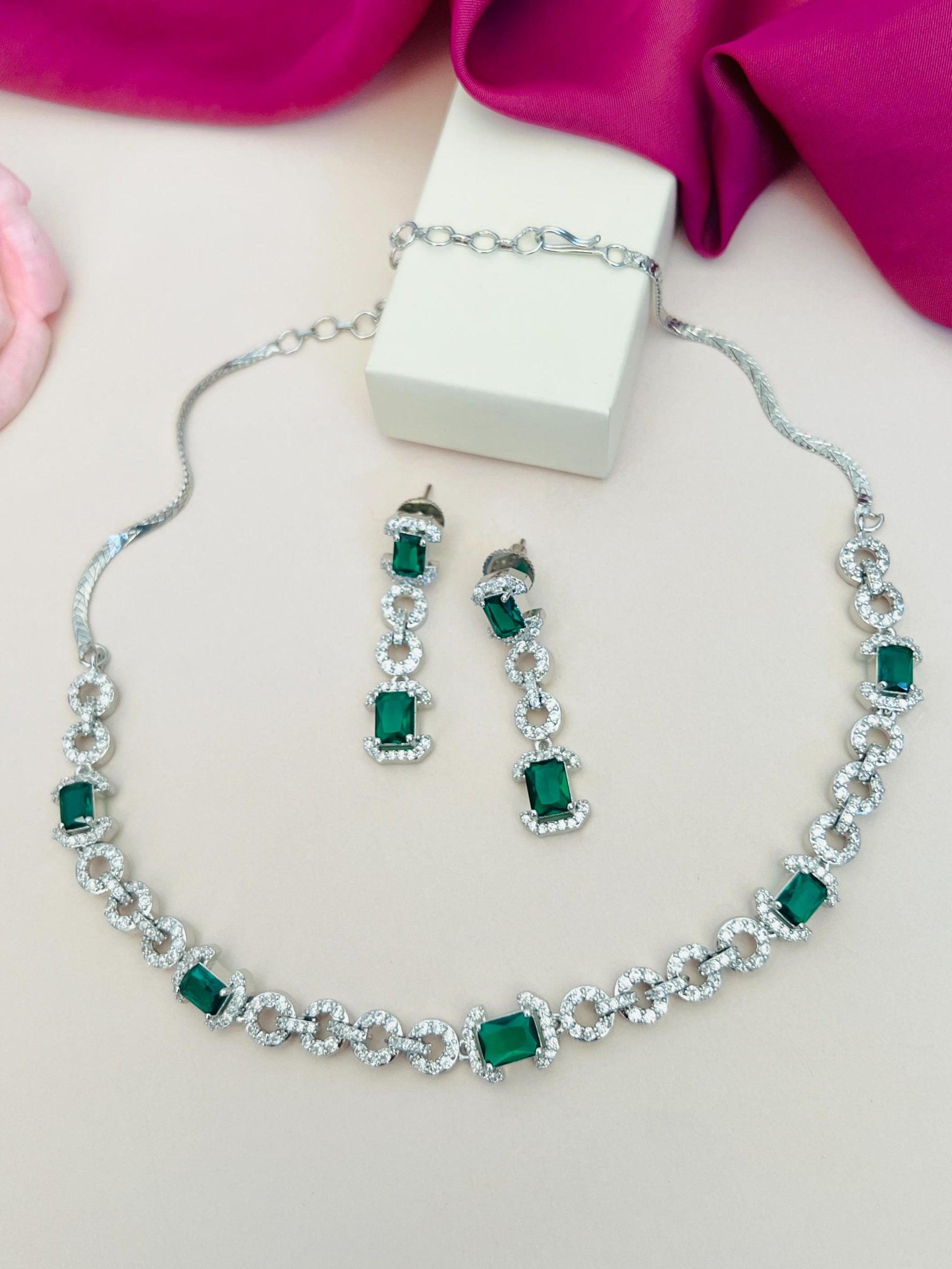 Abdesigns Jewellery Elegant Necklace with Green Gemstones silver cubic zirconia and matching drop earrings on beige backdrop