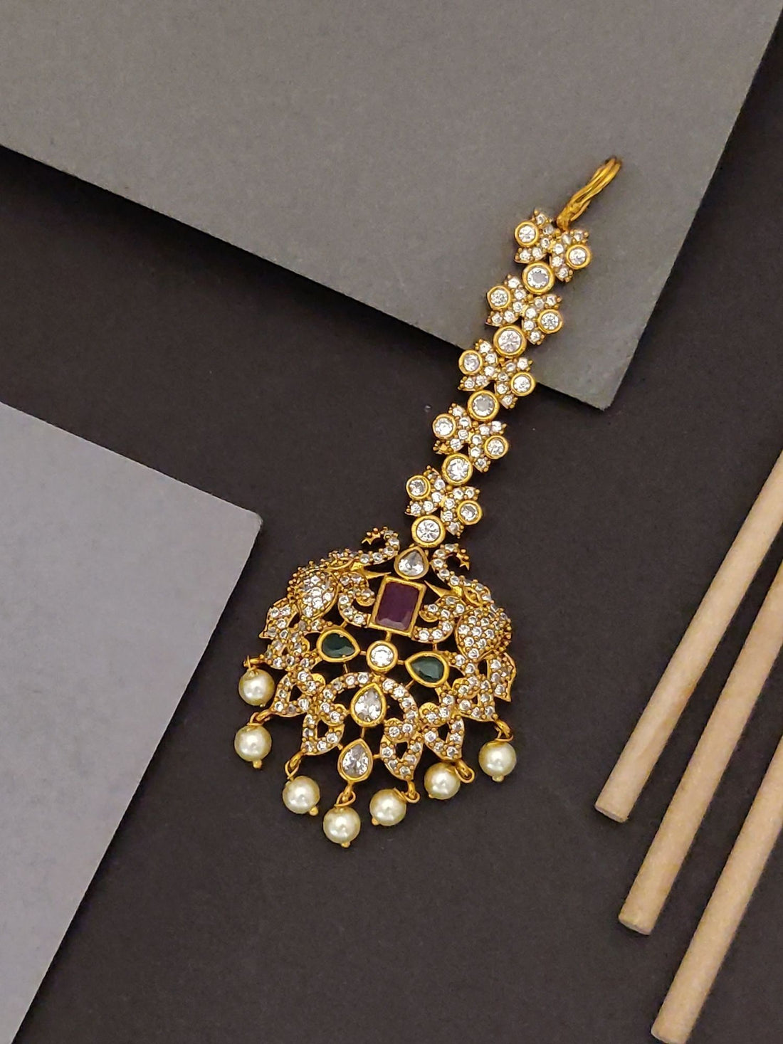 Abdesigns Jewellery Gold Kundan Maangtikka with Pearls.. ornate gold kundan tikka with green and red stones and dangling pearls