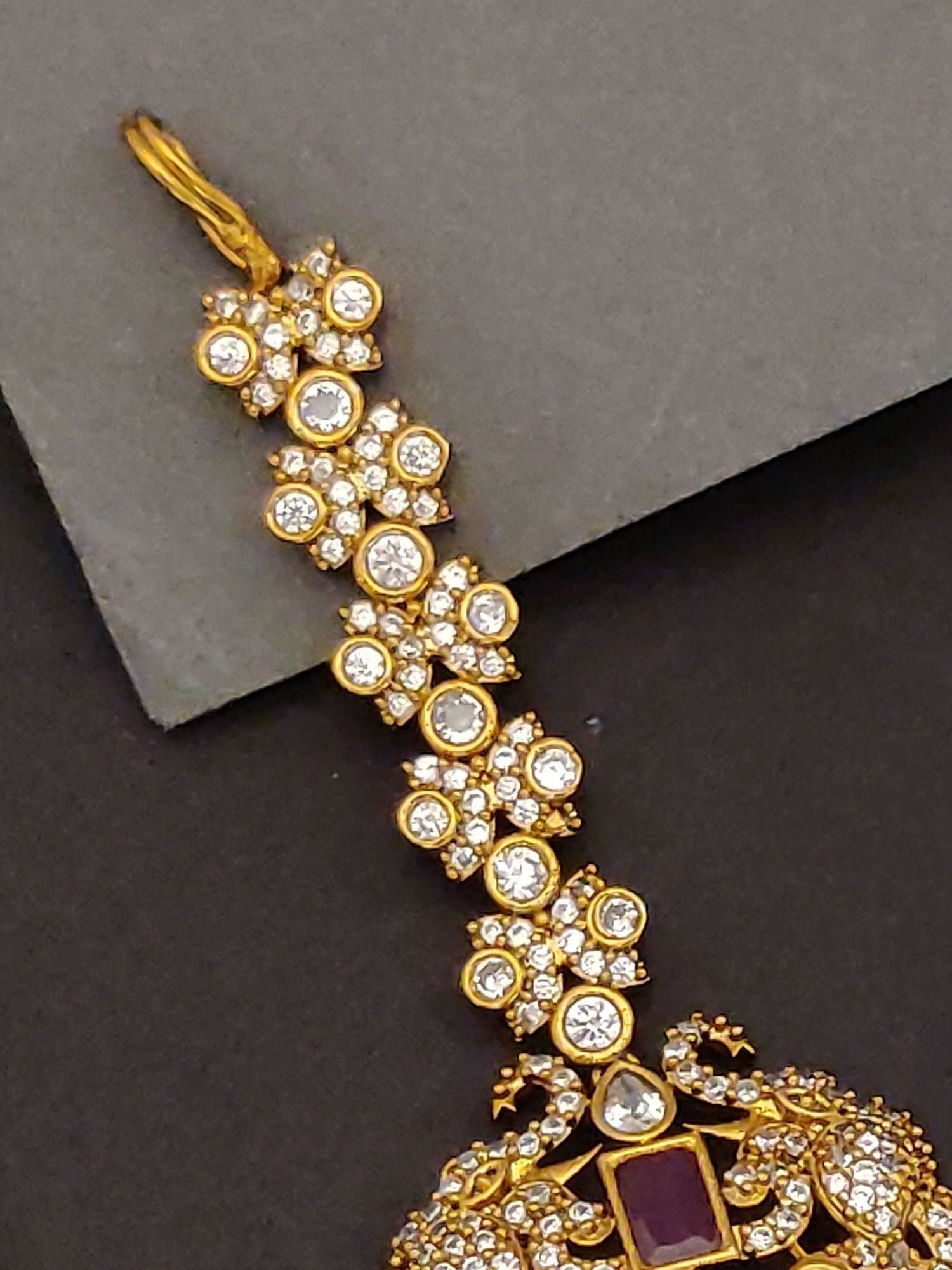 Abdesigns Jewellery Gold Kundan Maangtikka with Pearls.. ornate gold kundan maangtikka with clear stones and purple center pendant