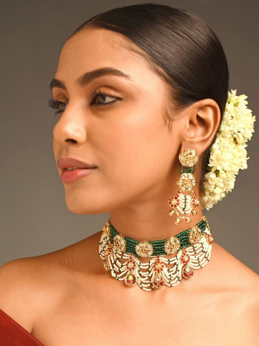 Model wearing Abdesigns Jewellery Traditional Green Beaded Necklace choker with gold filigree and red stone accents for bridal wear