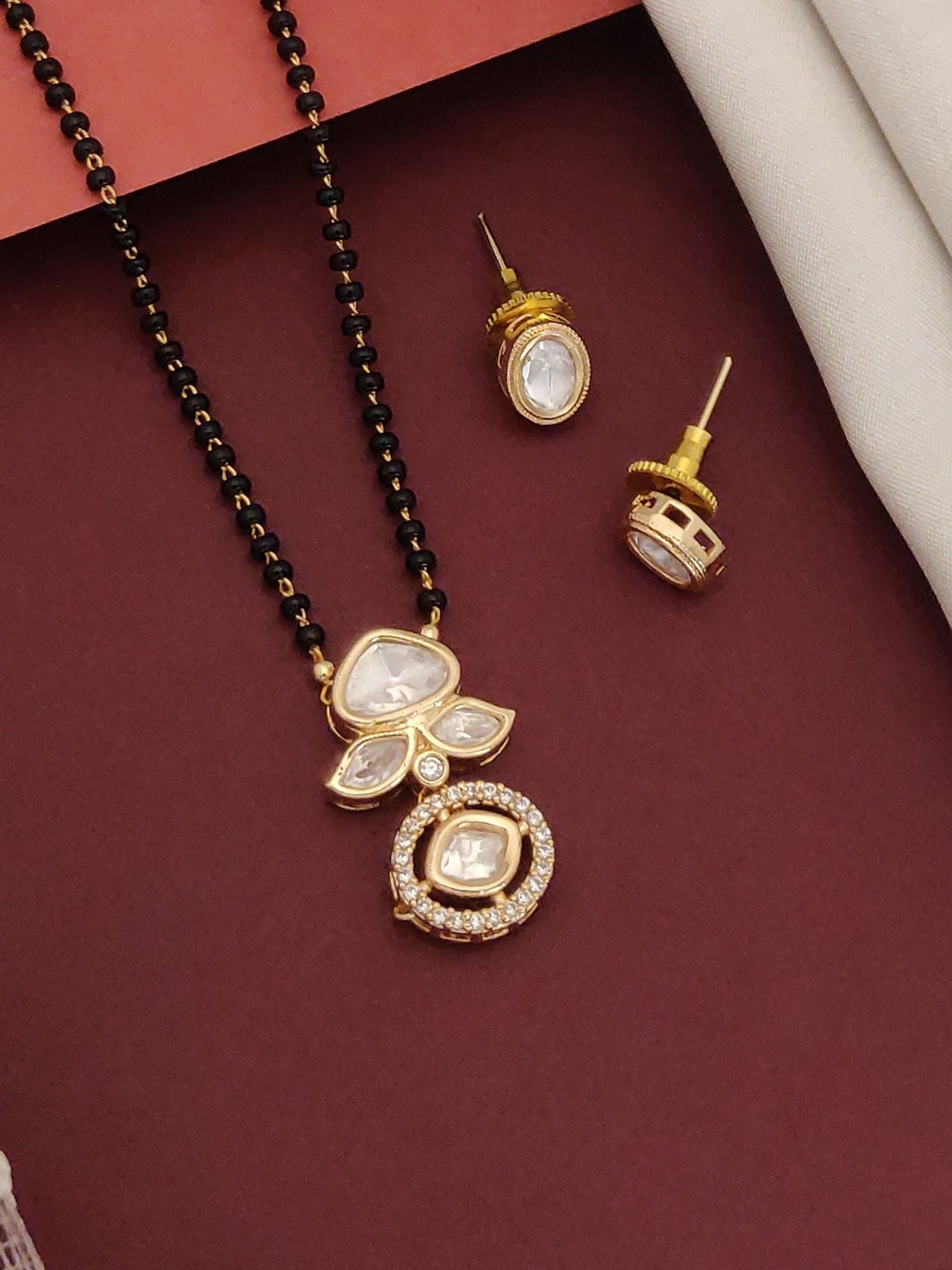 Abdesigns Luxe gold plated mangalsutra for women. Black bead mangalsutra with kundan pendant and matching studs