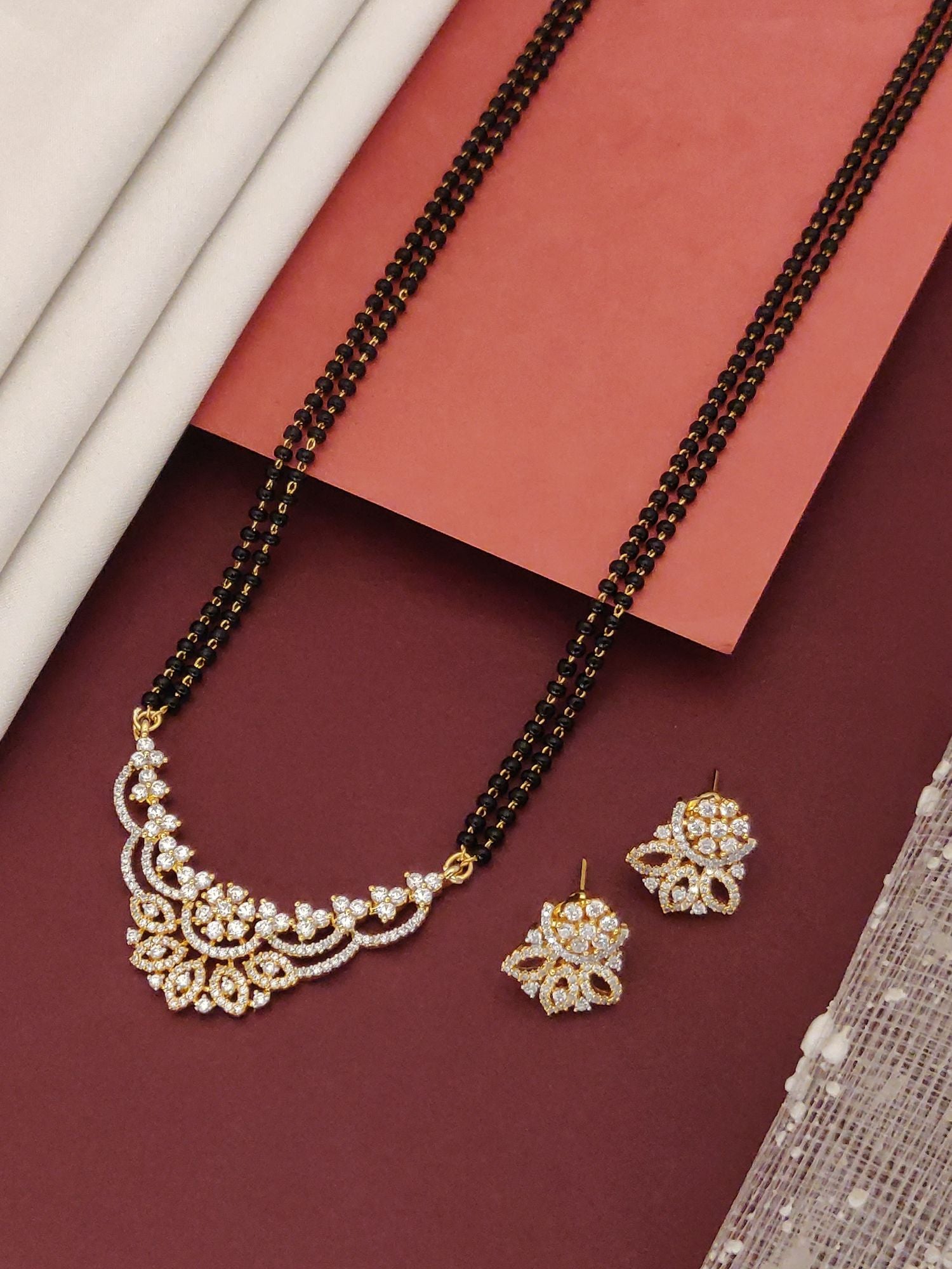 Abdesigns Opulent gold plated mangalsutra for women. Black beaded chain with gold floral pendant and earrings