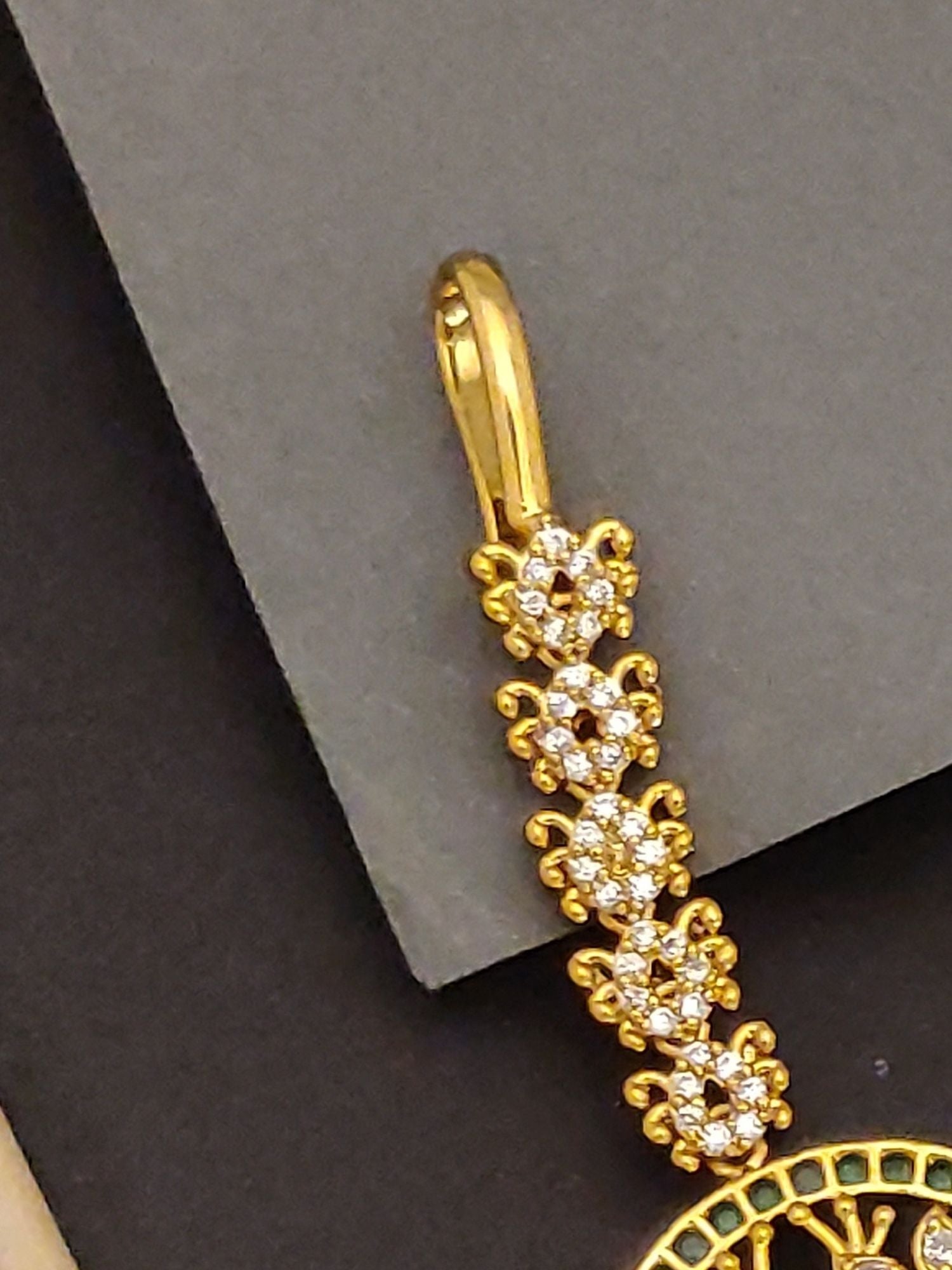 Abdesigns peacock design maangtikka for Women. Gold plated maangtikka close up showing floral stone chain and peacock pendant