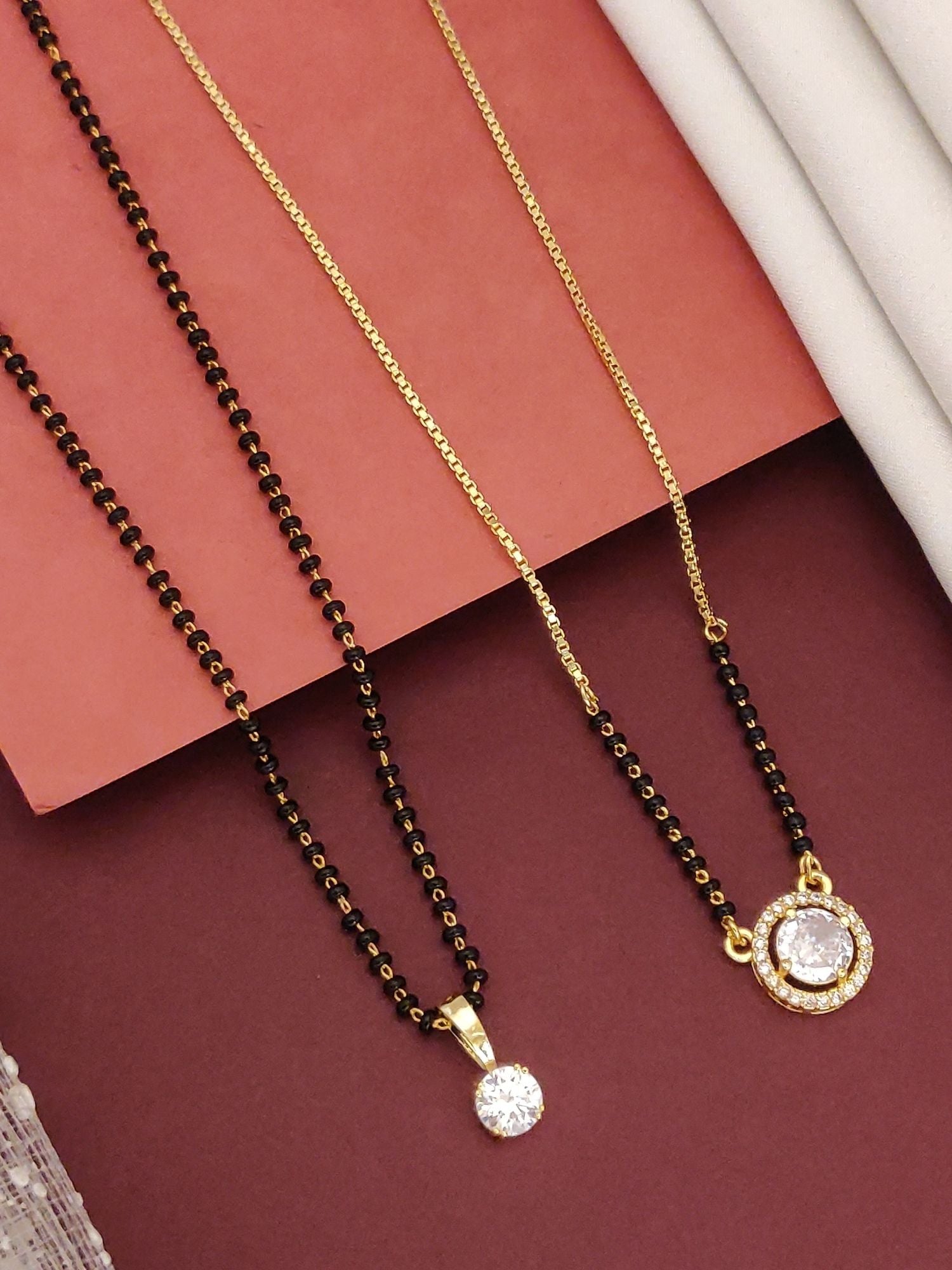 Abdesigns Regal Set of 2 gold plated mangalsutra combo for women. Gold plated chains with black beads and round crystal pendants