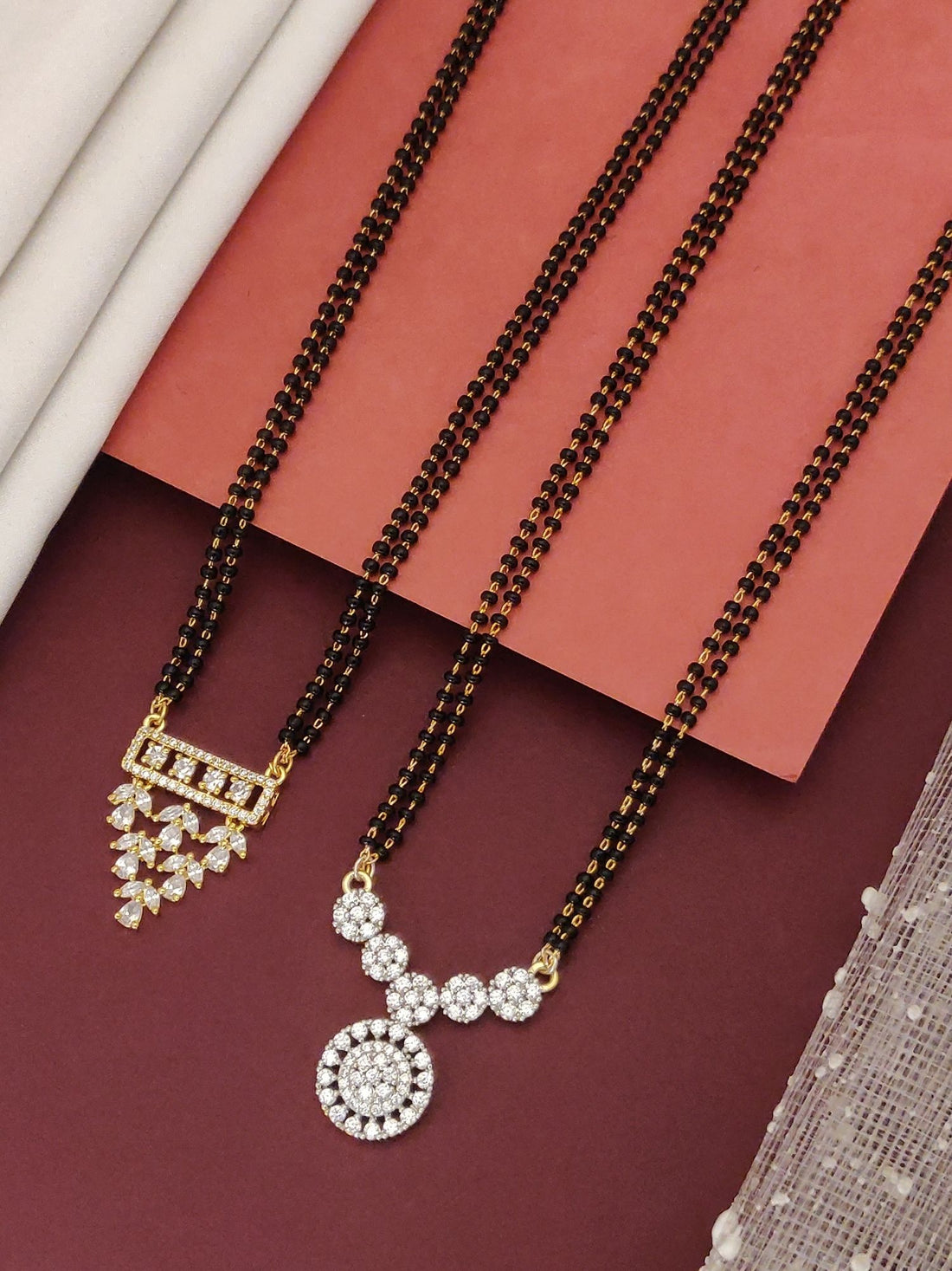 Abdesigns Set of 2 Detailed gold plated mangalsutra combo for women. Two black bead chains with floral and geometric gold pendants