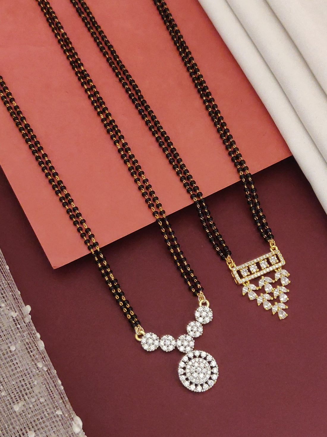 Abdesigns Set of 2 Detailed gold plated mangalsutra combo for women. Two black bead chains with floral and geometric gold pendants