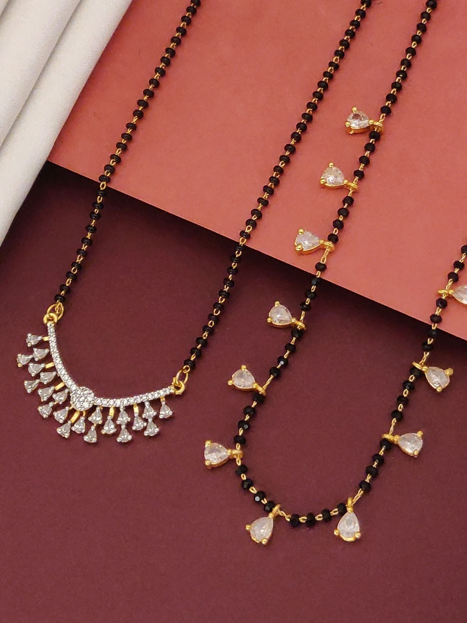 Abdesigns Set of 2 gold plated mangalsutra combo for women. Two black beaded gold plated necklaces with teardrop crystal pendants