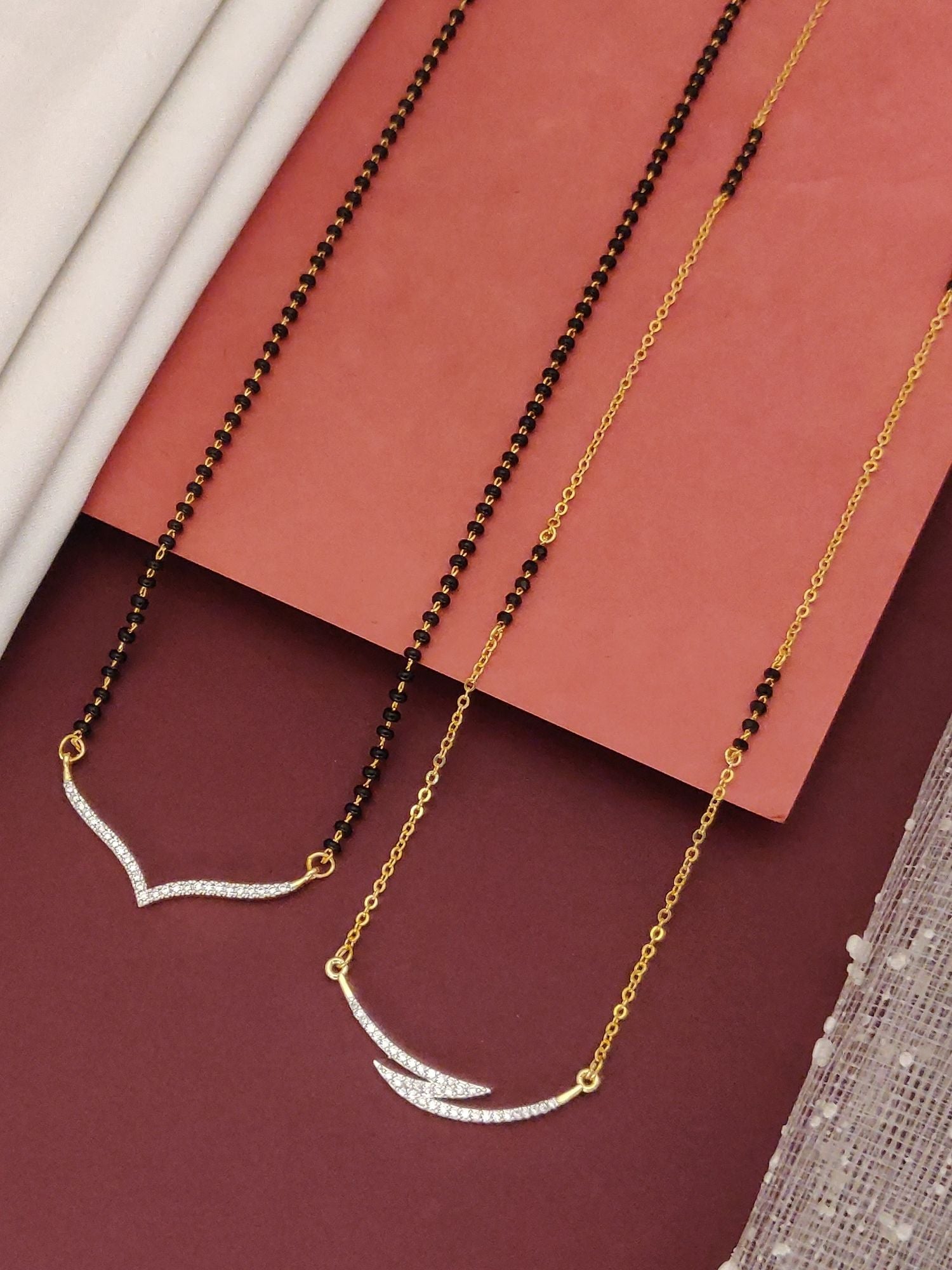 Abdesigns Set of 2 gold plated mangalsutra combo for women. Two gold mangalsutras with black beads and V shaped stone pendants