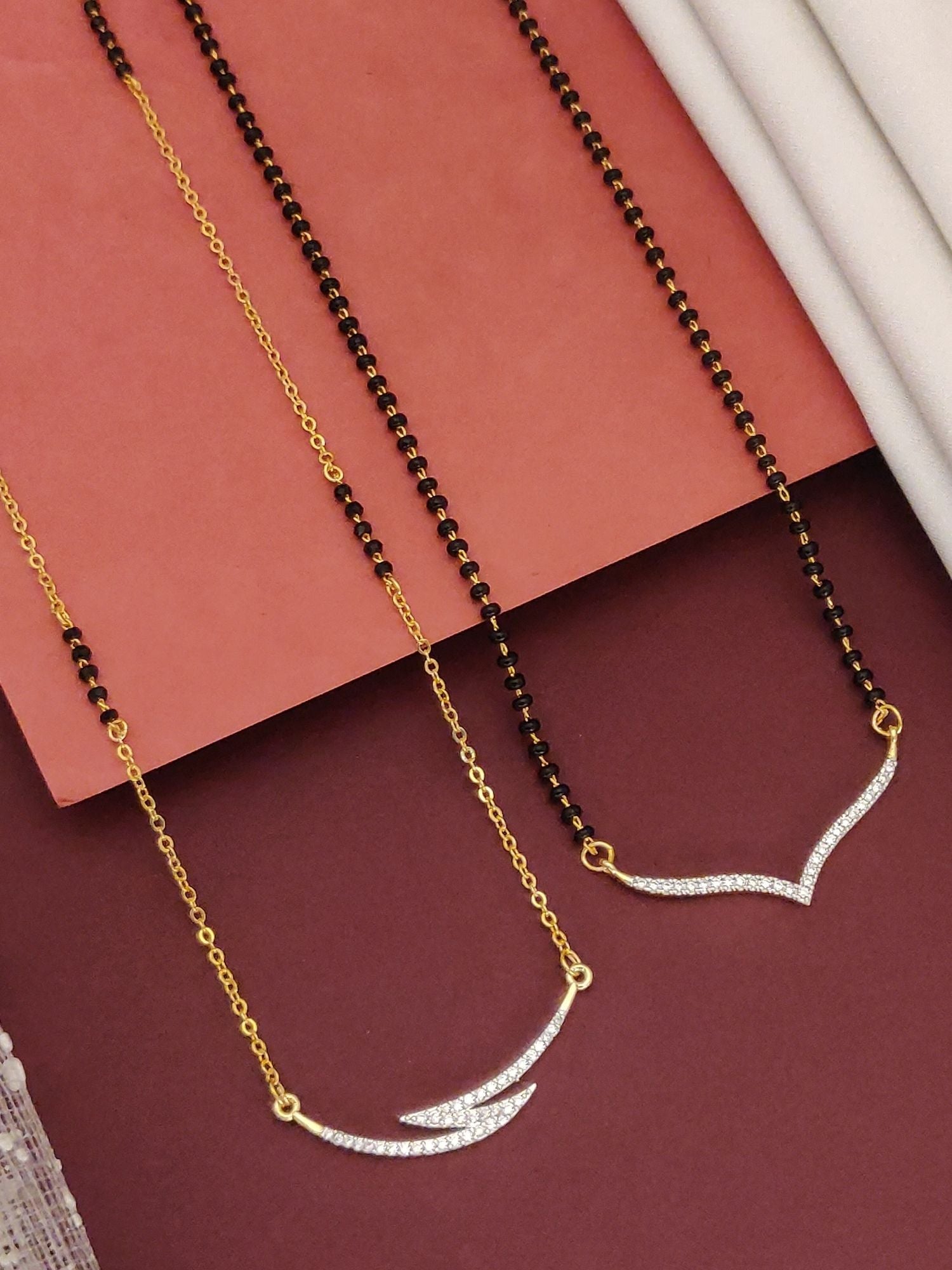 Abdesigns Set of 2 gold plated mangalsutra combo for women. Two black bead chains with V shaped crystal pendants