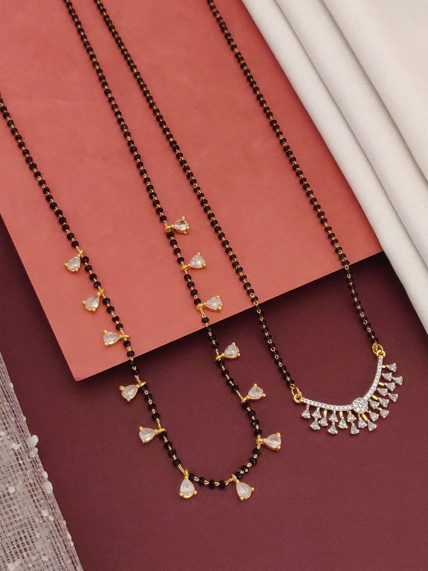 Abdesigns Set of 2 gold plated mangalsutra combo for women. Two black bead chains with gold teardrop and diamond fan pendants