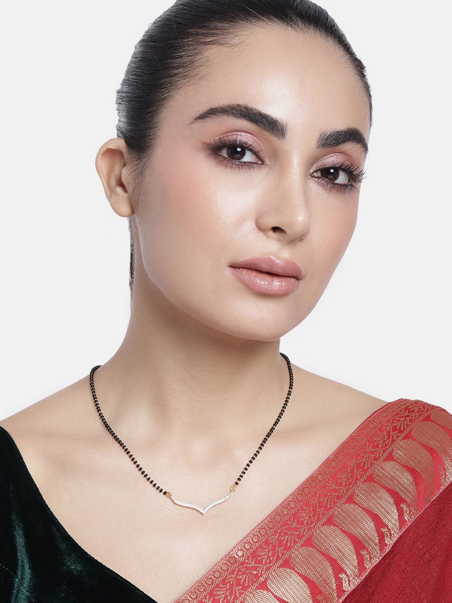 Model wearing Abdesigns Set of 2 gold plated mangalsutra combo for women. Two delicate black bead chains with V shaped gold pendant