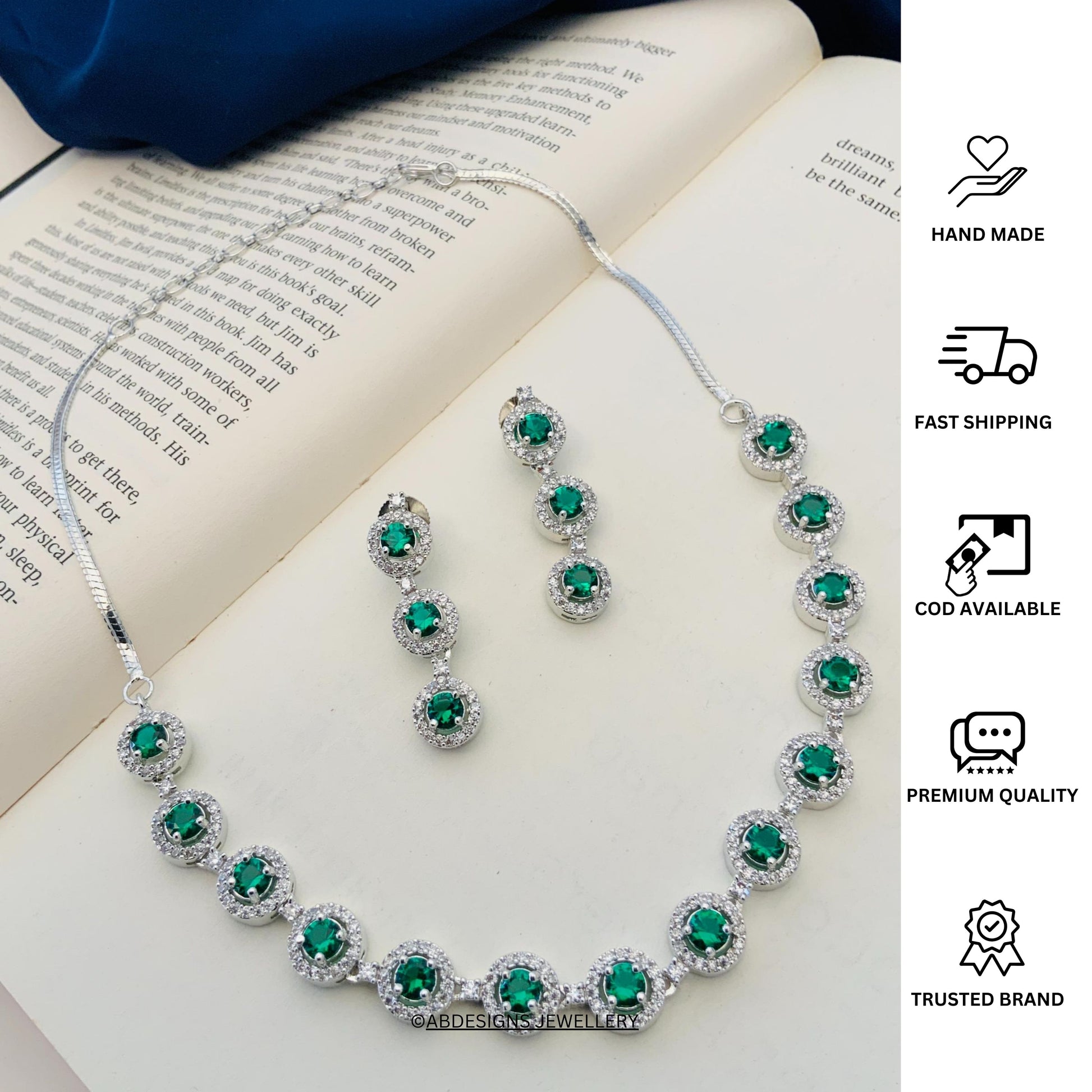 Abdesigns Silver Plated American Diamond Necklace Set with green stones and matching drop earrings on book
