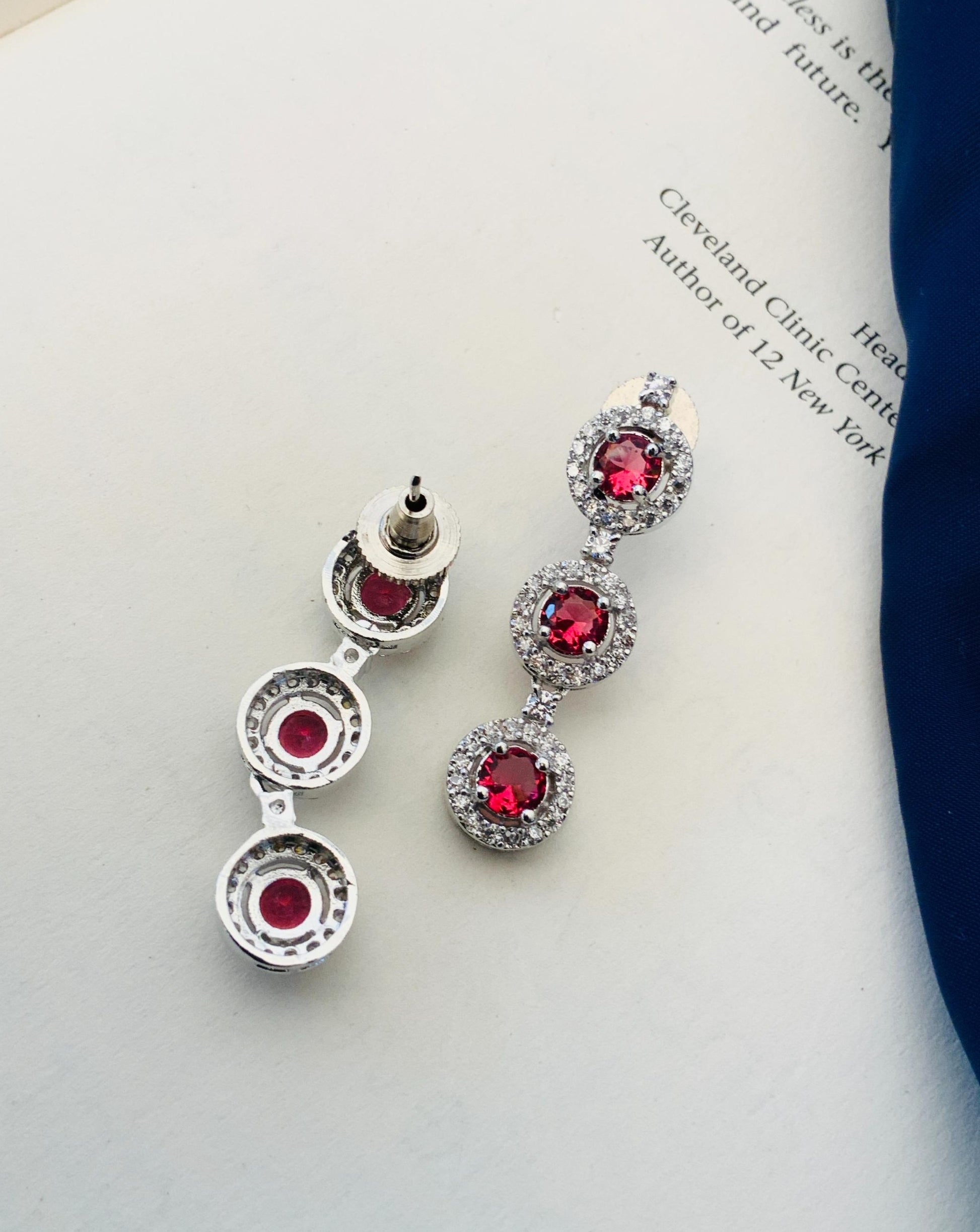 Abdesigns Silver Plated American Diamond Necklace Set silver drop earrings with three red stones and clear crystals on white